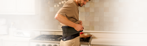 A man wearing a back brace whilst in a kitchen 