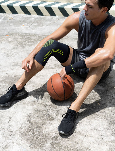 Man wearing Neo G Active Knee Support sitting down with basketball