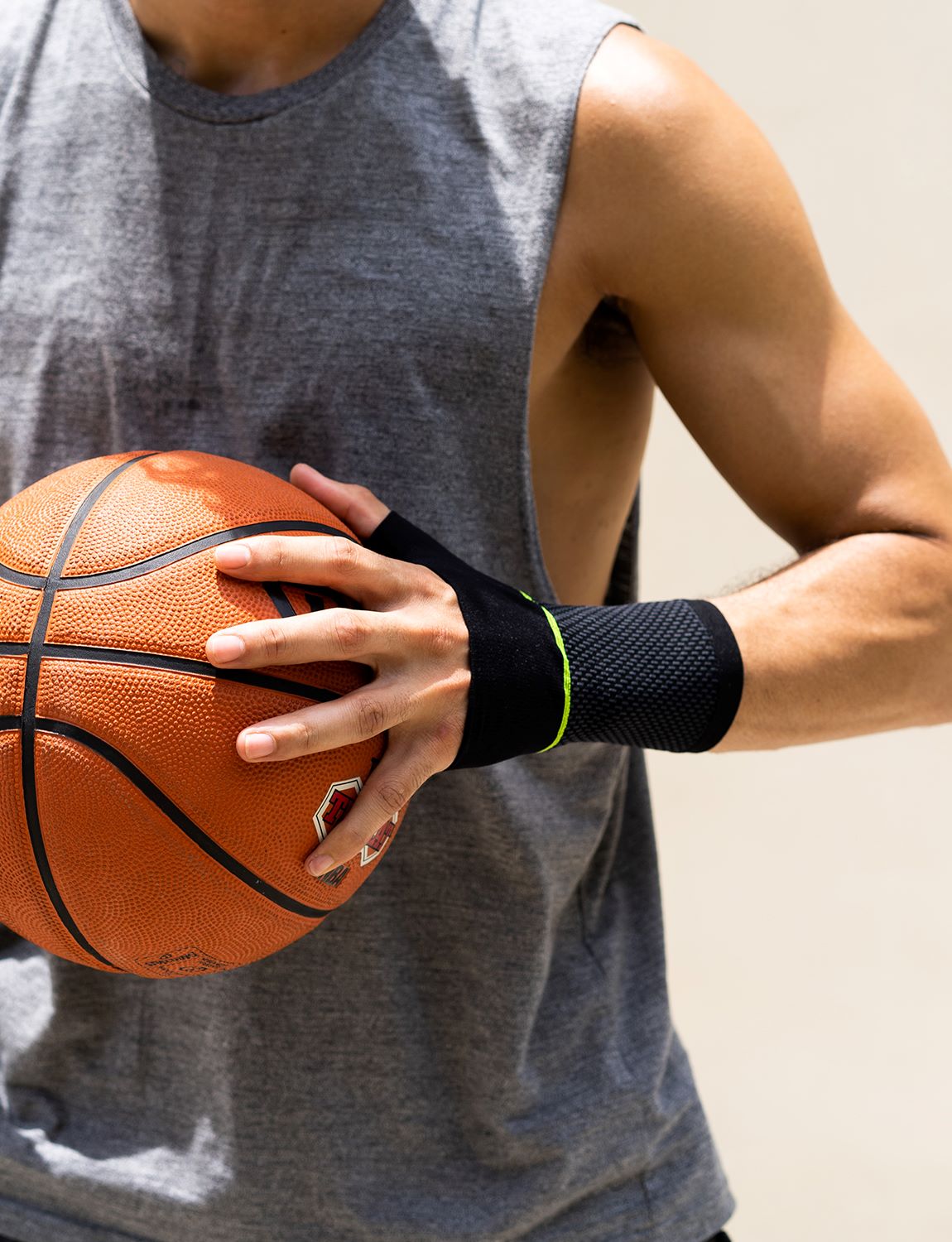 Man wearing Neo G Active Wrist Support holding basketball