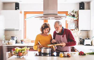 Older couple with arthritis enjoying cooking a meal together